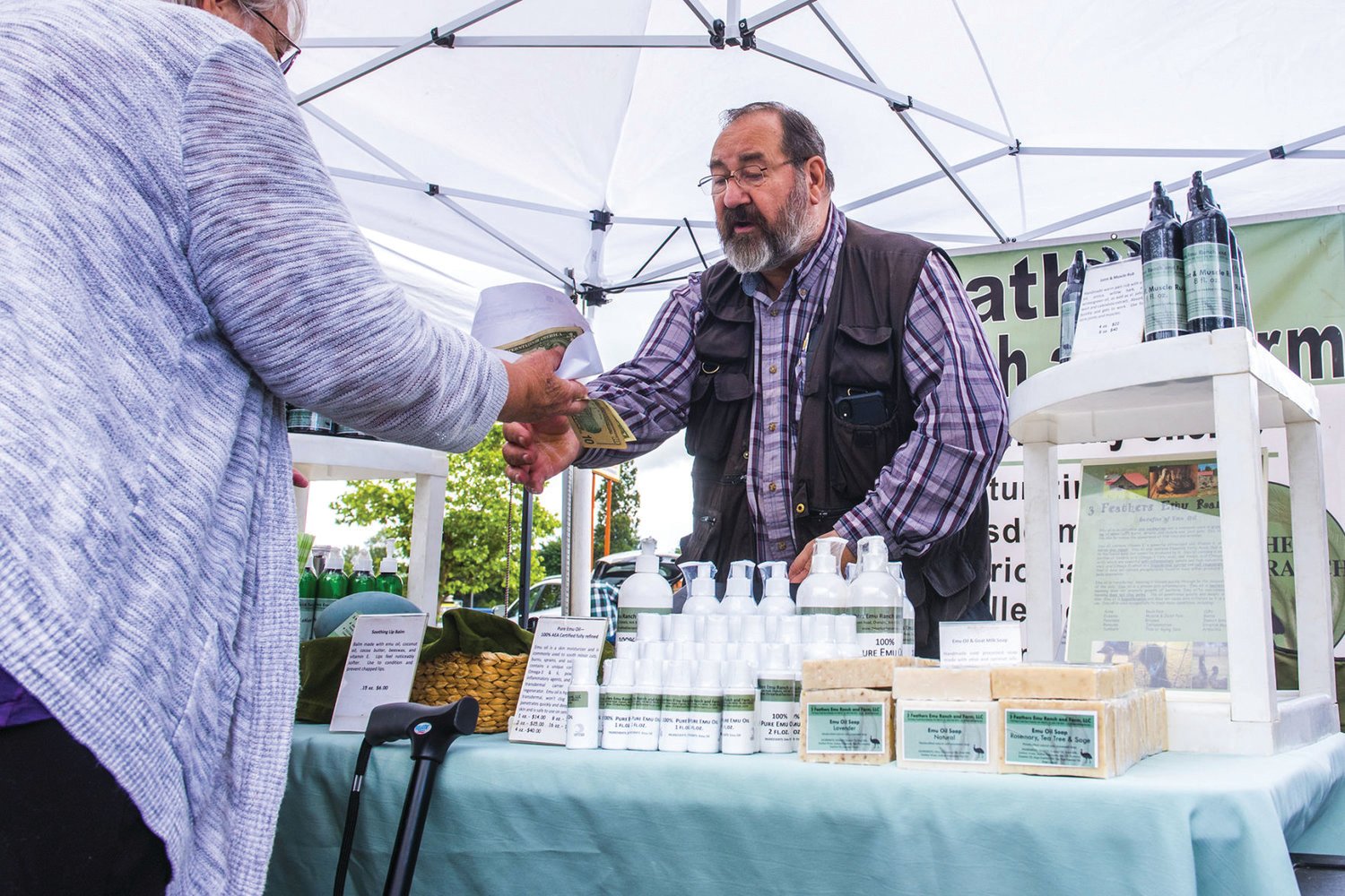 Tony Citrhyn sells product from 3 Feathers Emu Ranch to a customer at the Centralia Farmers Market in 2019.